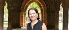 Carol Andrews standing outside the main building at the University of Glasgow