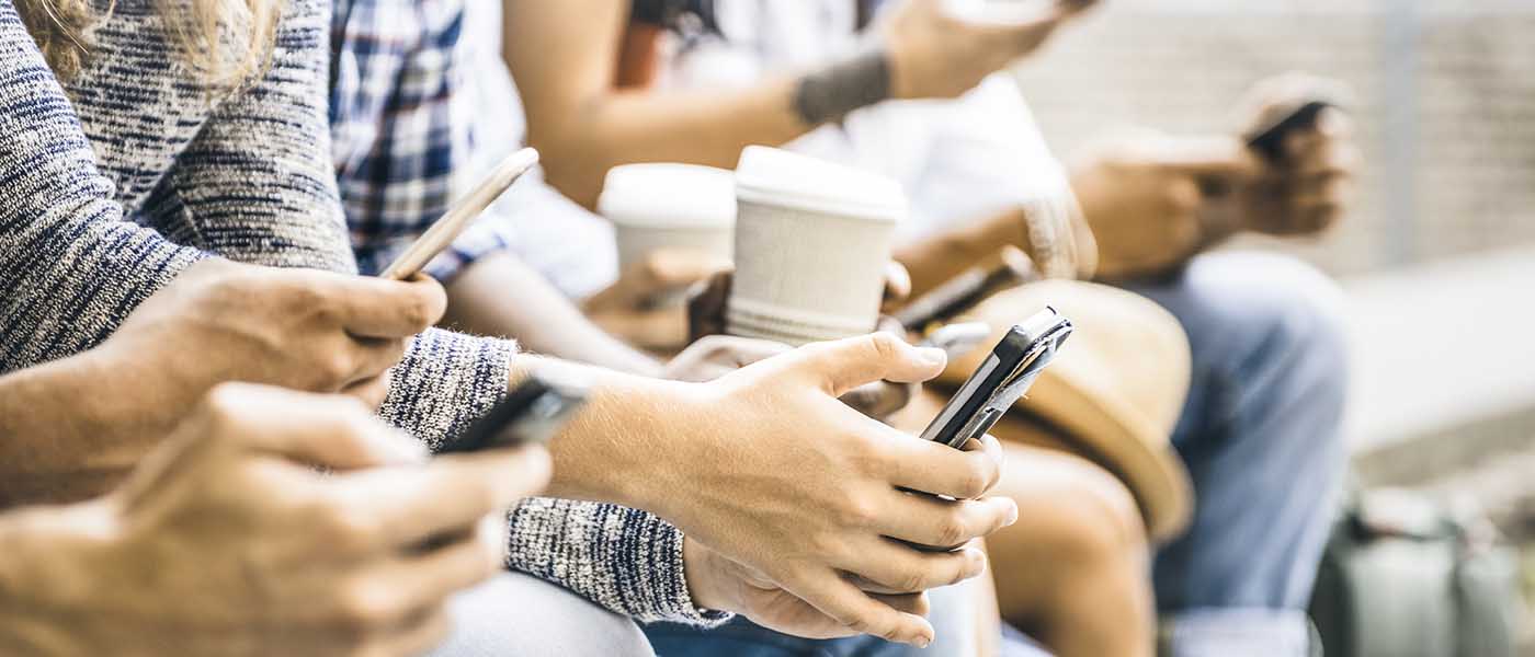 Close up of group of young people using Mobile Phones